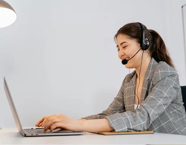 A specialist in a headset working at a laptop