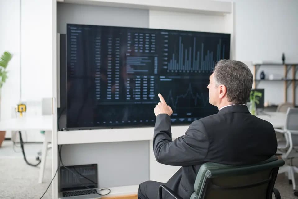 A colleague reading figures on a large office display