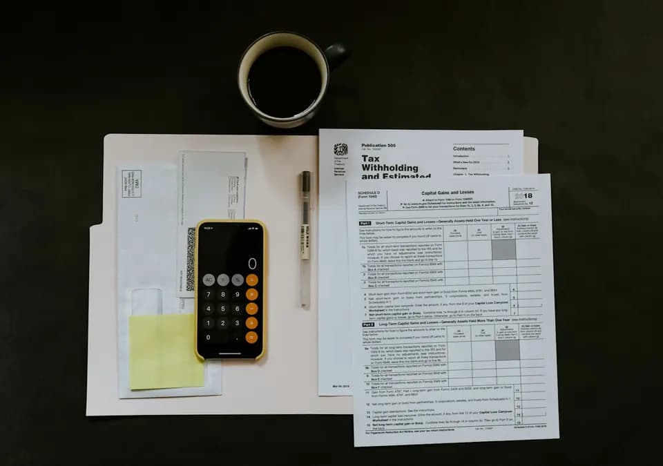 Financial documents filed in a folder with a phone alongside