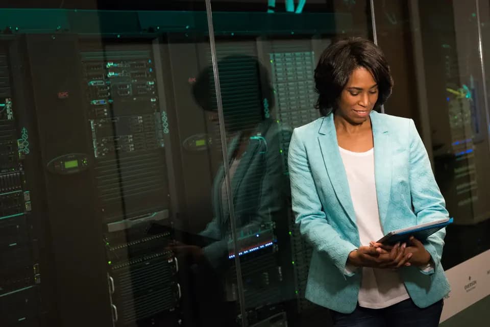 An engineer reading a tablet in front of data-centre equipment