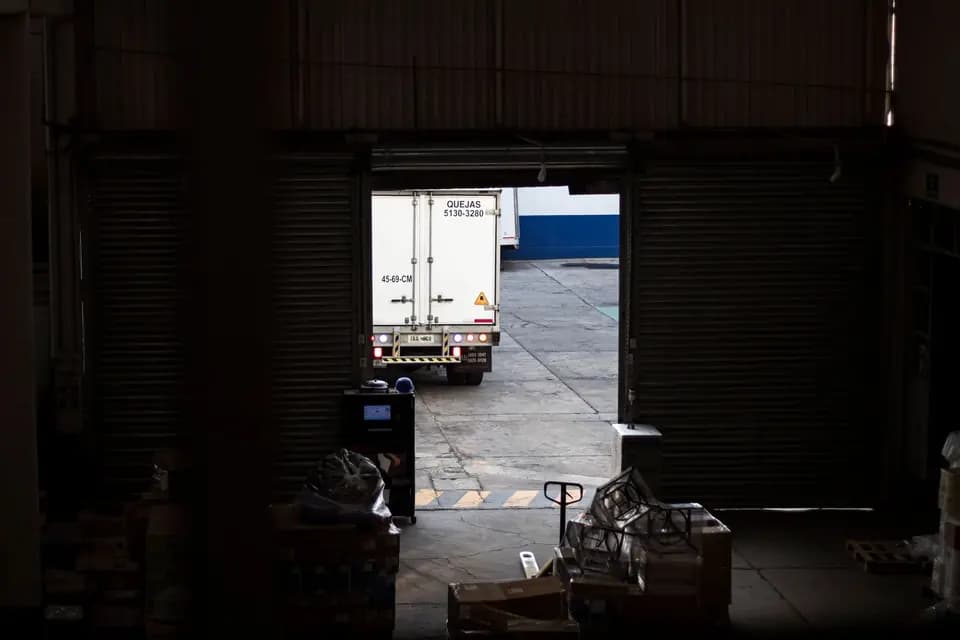 A delivery lorry pulling away from a warehouse loading dock
