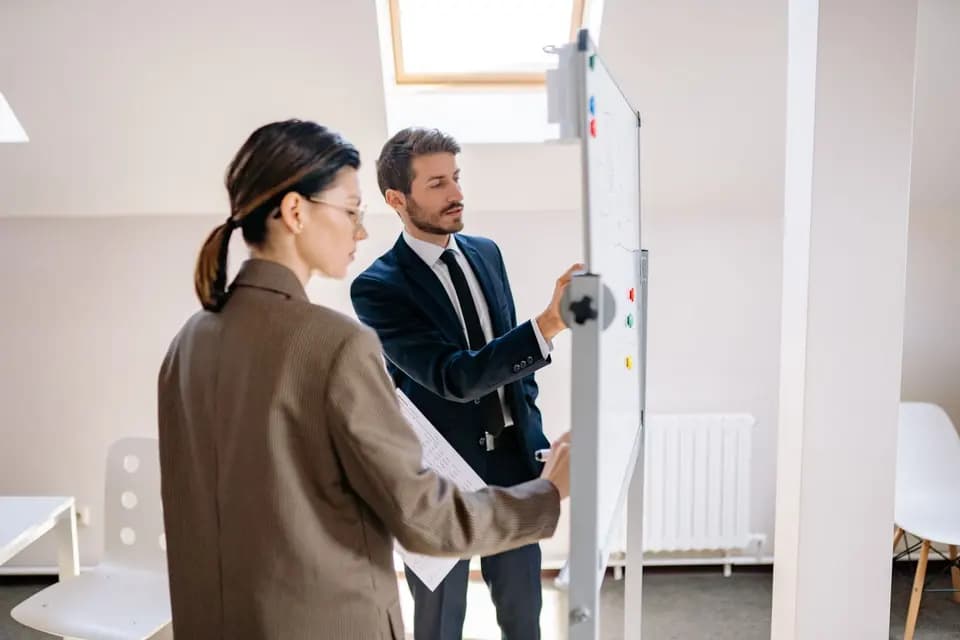 Two colleagues working at a whiteboard together
