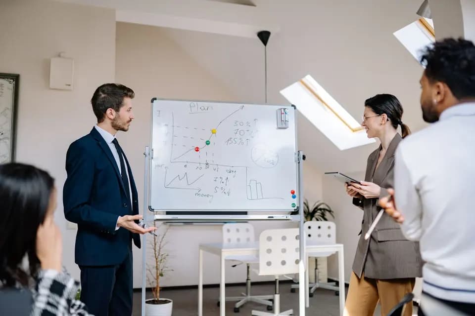 Colleagues working through charts drawn on a whiteboard