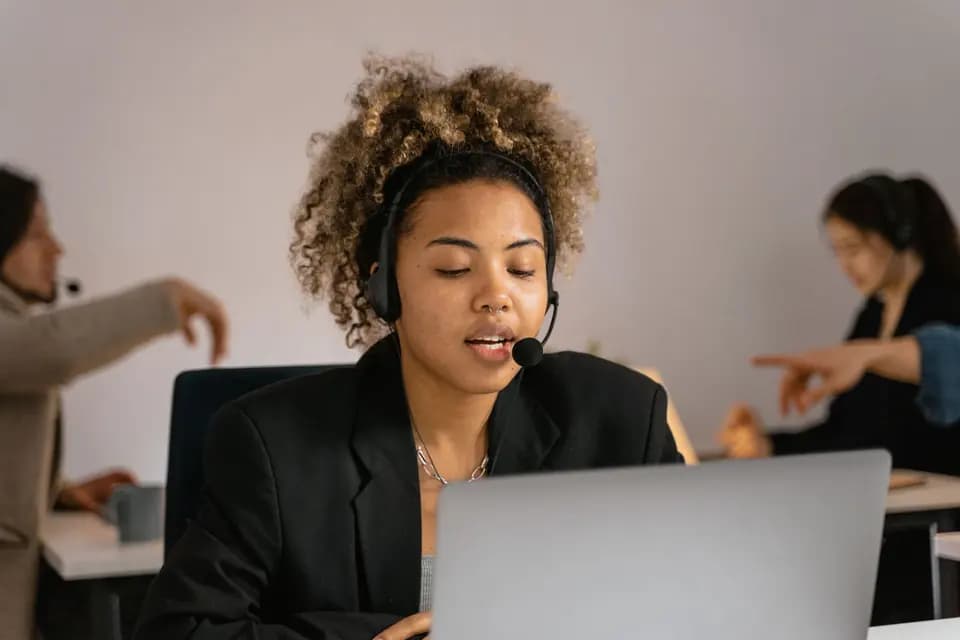 A specialist in a headset working at a laptop