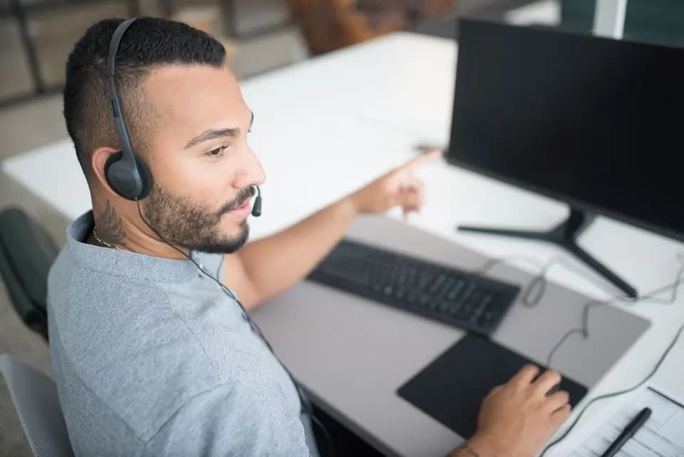 A support engineer in a headset concentrating on a screen