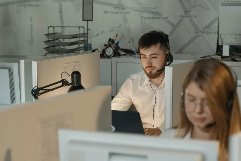A support agent in a headset working at a desk