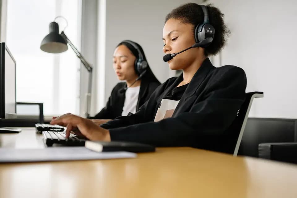 Two support agents working side by side at their desks