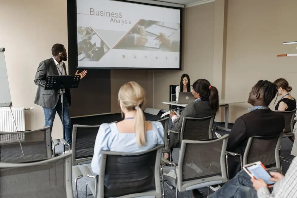 A presenter addressing colleagues seated in a training room