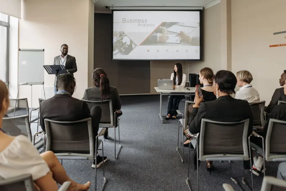 A trainer speaking to attendees seated in rows